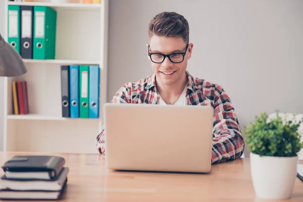 Smiling concentrated man in glasses writing book on laptop — Stock Photo, Image