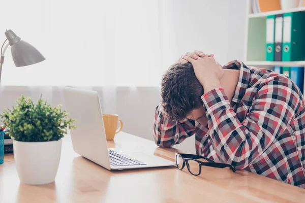 Utmattad överarbetade unga manager med huvudvärk liggande på bordet — Stockfoto