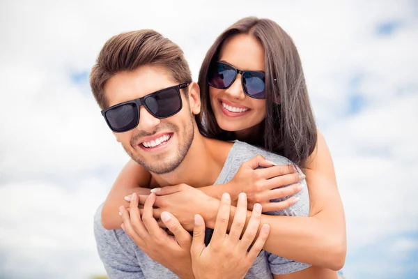 Sorrindo homem feliz piggybacking sua namorada no dia de verão e — Fotografia de Stock