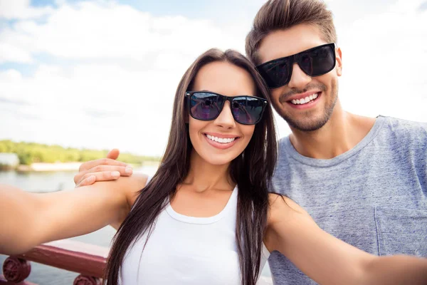 Selfie of happy cute lovers in glasses having walk in city — Stock Photo, Image