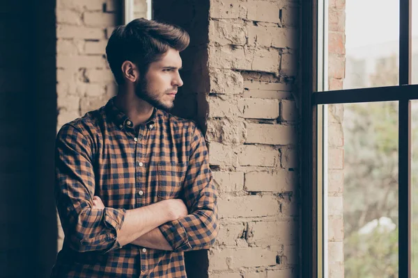 Retrato de un joven con las manos cruzadas mirando por la ventana — Foto de Stock