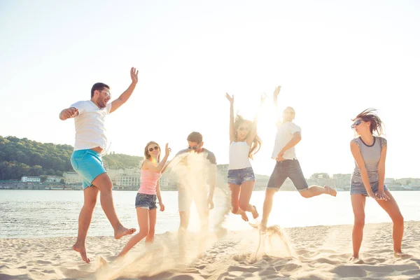 Unbekümmerte junge Leute, die Spaß haben und aufs Meer springen — Stockfoto