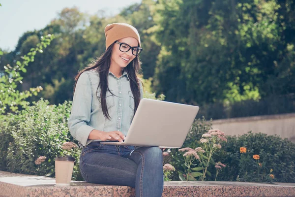 Счастливая хипстер молодая женщина работает на ноутбуке в парке — стоковое фото