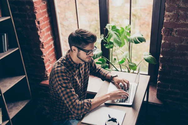 Top view of handsome  young man in glasses typing on laptop — Stock Photo, Image