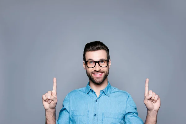 Portret van jonge vrolijke bebaarde man in glazen gebaren omhoog — Stockfoto