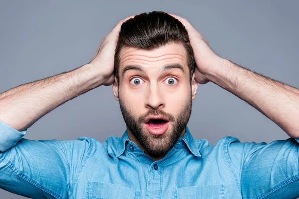Portrét šokován mladého muže s otevřenou hubou dotýkat hlavy — Stock fotografie