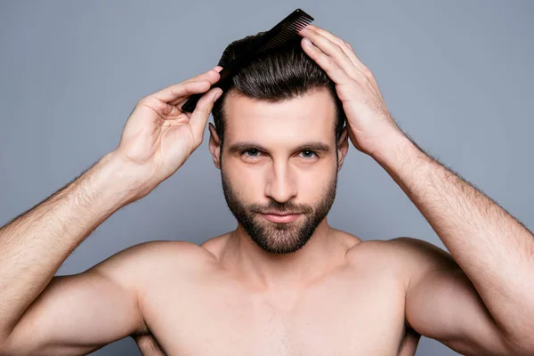 Portrait of handsome young guy combing his hair — Stock Photo, Image