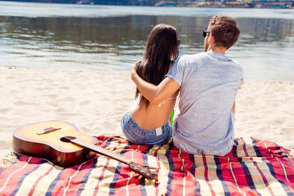 Baksidan på ungt par dating och allomfattande på picknick — Stockfoto