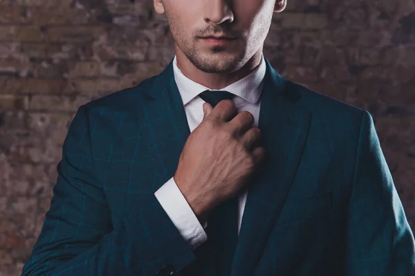 Close up de homem elegante em terno preto corrigindo gravata — Fotografia de Stock