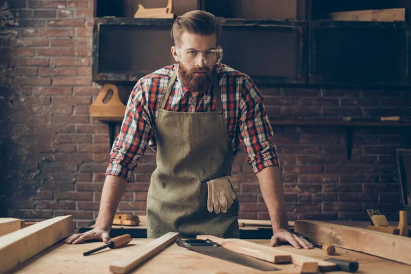 Bebaarde knappe schrijnwerker op het tafelblad met tools. Styli — Stockfoto