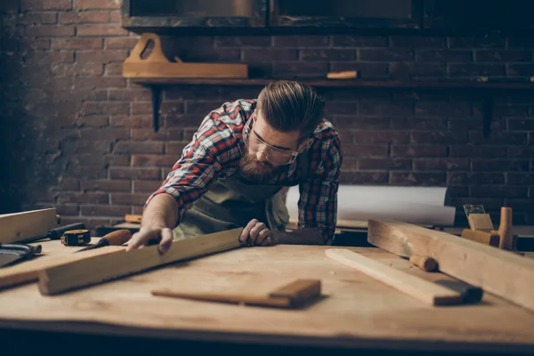 Skäggiga stilig möbelsnickare på bordsskiva med verktyg. Mätspetsar — Stockfoto
