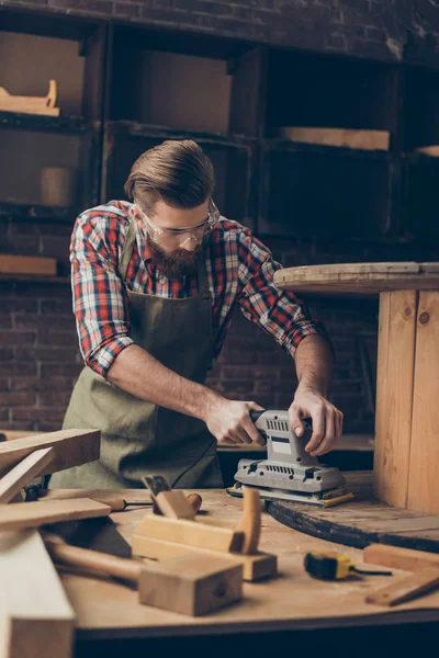 Allvarlig stilig hantverkare arbetar med slipmaskin för trä. Eleganta y — Stockfoto