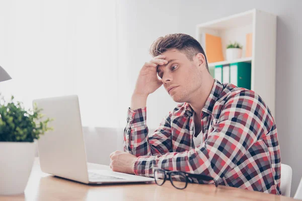 Overwerkt jongeman denken van het oplossen van moeilijke taak op wor — Stockfoto