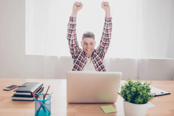 Excited man completed task and triumphing with raised hands