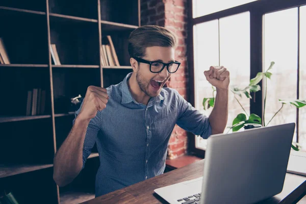 Fatto! Felice uomo eccitato alzato le mani e guardando il computer portatile in mo — Foto Stock