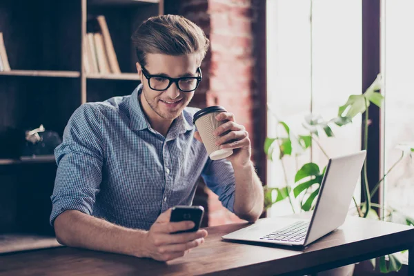 Jonge glimlachend werknemer drinken koffie en het bericht aan het typen — Stockfoto