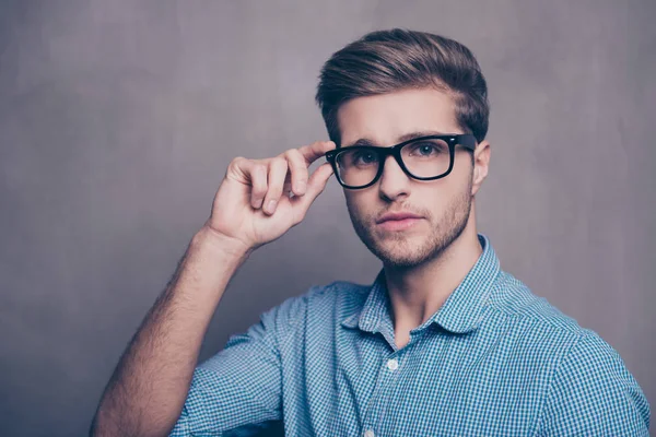 Ritratto di bel giovane uomo serio che tocca gli occhiali — Foto Stock