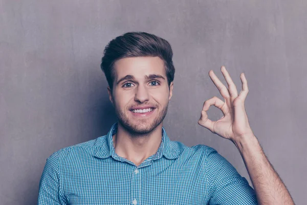 Retrato de un joven con camisa azul a cuadros mostrando el gesto de la mano — Foto de Stock