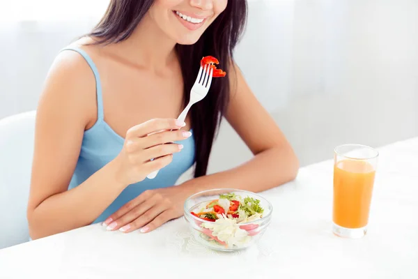 Крупним планом усміхнена жінка їсть свіжий салат за столом біля г — стокове фото