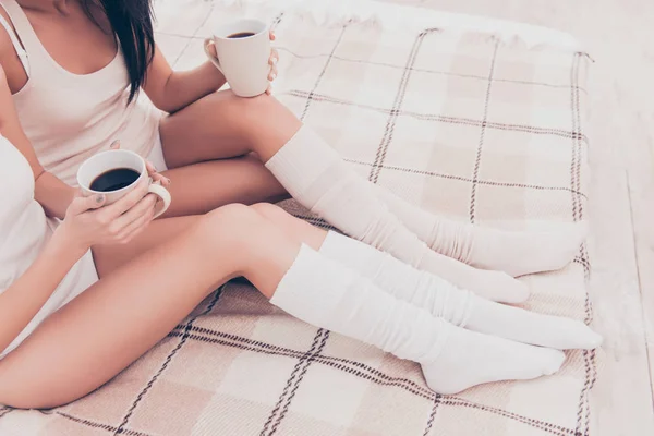 Primer plano de dos mujeres jóvenes sexy sosteniendo tazas de café en las manos —  Fotos de Stock