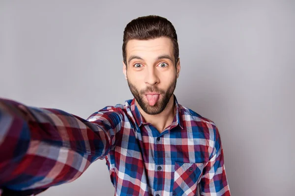 Playful stylish man isolated on gray background showing tongue a — Stock Photo, Image