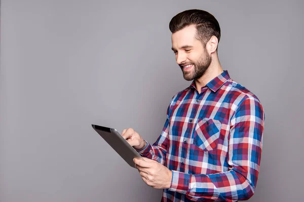 Sonriente hombre elegante aislado sobre fondo gris sosteniendo su tabl — Foto de Stock