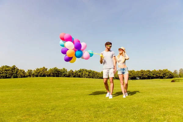 Jeune couple ayant week-end et marche avec des ballons — Photo