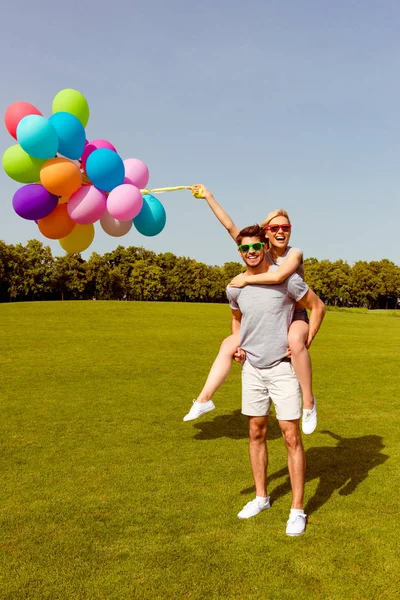 上周末和行走与气球开心的年轻夫妇。马 — 图库照片