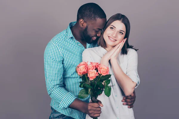 Lycklig afro man med rosor som omfamnar hans vackra flickvän — Stockfoto