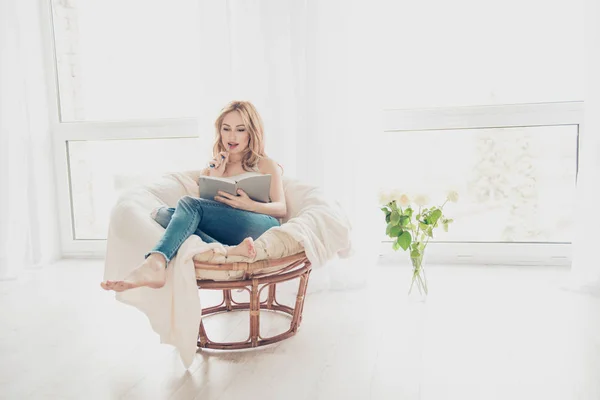Счастливая симпатичная женщина, пишущая в тетрадке, сидящая в — стоковое фото