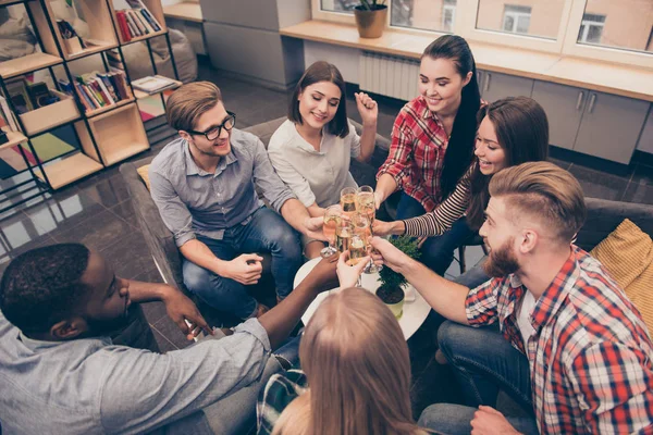 Skål! Grupp av multietniskt vänner sitter på soffan med drink — Stockfoto