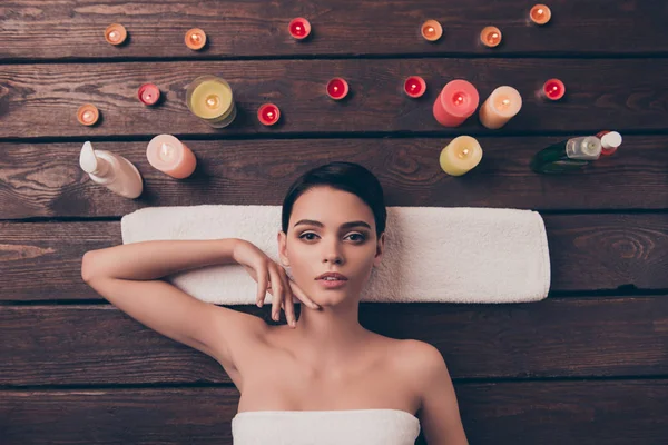 Aardige ontspannen jonge vrouw in spa salon over handdoek te leggen — Stockfoto