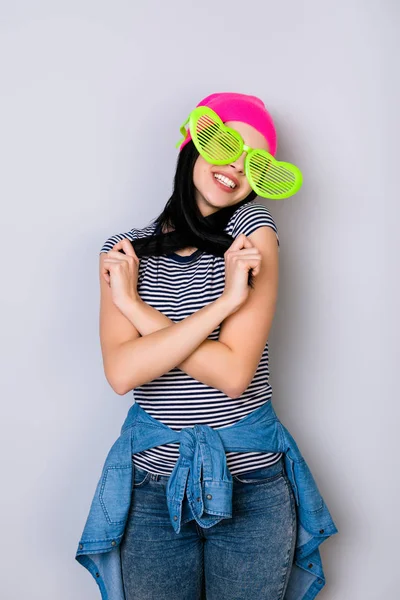 Jonge stijlvolle lachende vrouw draagt roze hoed en grote grappige glas — Stockfoto