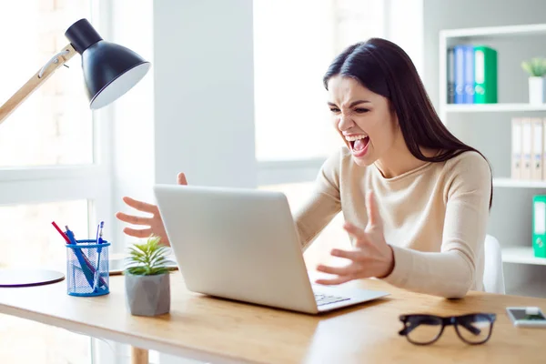 Angry irritated young businesswoman sitting at the table — Stock Photo, Image