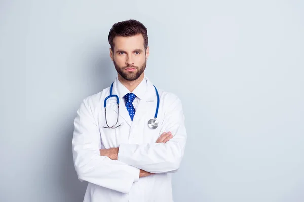 Porträt eines seriösen, gut aussehenden männlichen Arztes mit gekreuzten Händen — Stockfoto