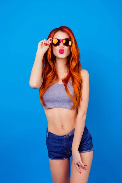 Agradable chica despreocupada encantadora haciendo pucheros labios rosados y sosteniendo gafas de sol — Foto de Stock