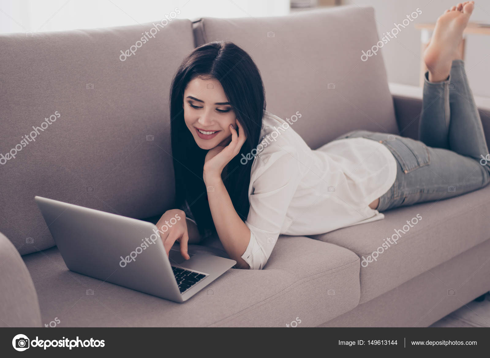 devushka-v-dzhinsah-lezhit-na-divane-foto