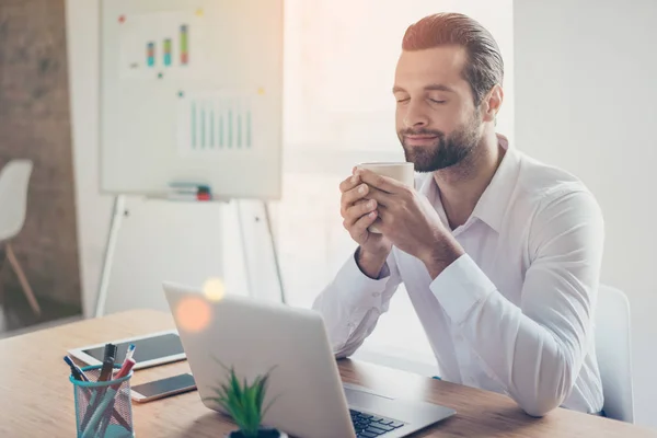 Hombre de negocios joven guapo en camisa blanca se sienta a la mesa en — Foto de Stock