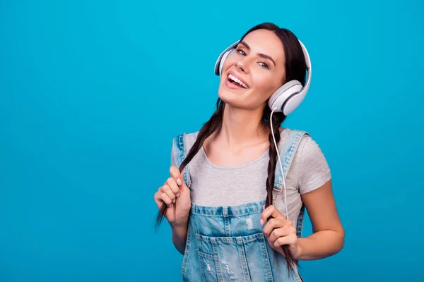 Portrait of cute young girl with funny pigtails in jeans overall — Stock Photo, Image