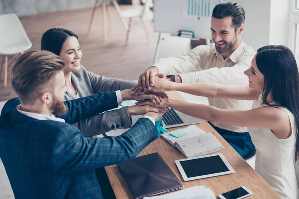 ¡Todos juntos! Felices empresarios poniendo sus manos en la parte superior de — Foto de Stock