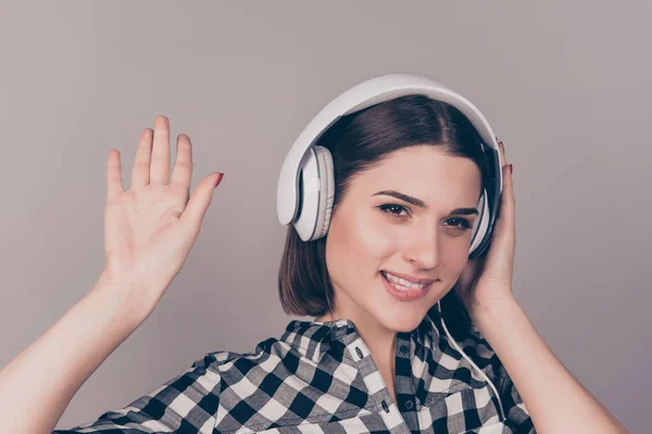 Charmig ung kvinna i rutig skjorta lyssnar på musik och w — Stockfoto