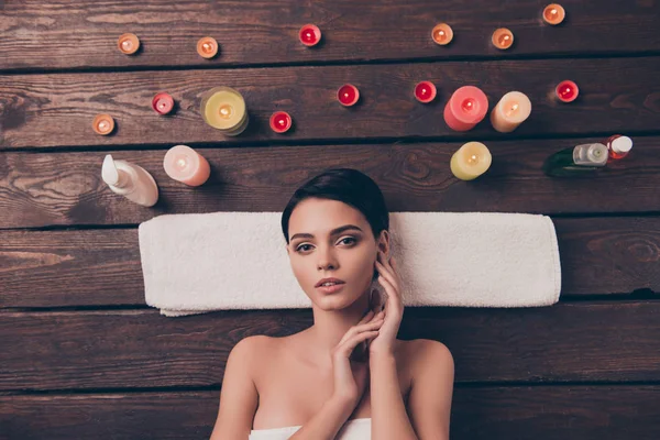 Leuke mooie ontspannen jonge vrouw die in spa salon over handdoek te leggen — Stockfoto