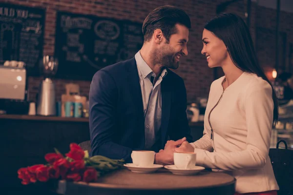 Happy romantic man and woman  sitting in a cafe with flowers — Stock Photo, Image