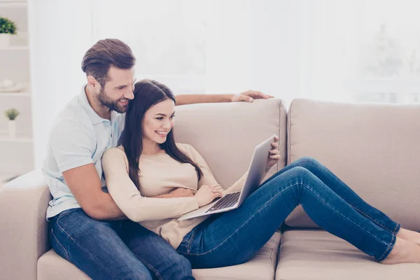 Glada par sitter hemma på soffan och arbetar som en fre — Stockfoto