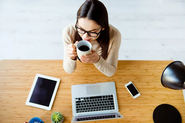 Top view of young cute businesswoman in glasses sits at the desk — Stock Photo, Image