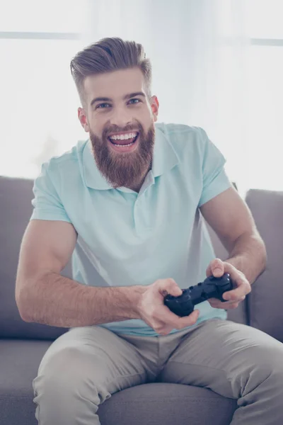 Ett porträtt av ung stilig bearded man håller joystick och pl — Stockfoto