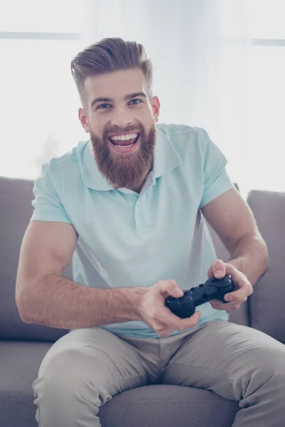 Um retrato de homem barbudo bonito jovem segurando joystick e pl — Fotografia de Stock