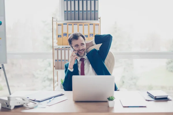 Gelukkig zakenman gaat op zijn telefoon, ontspannen en glimlachen. — Stockfoto