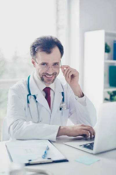 Portret van vrolijke gelukkig doctor in de bril zitten aan de balie — Stockfoto