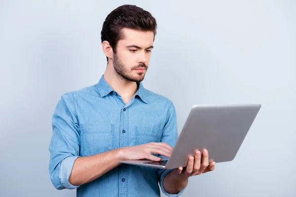 Portret koncentratu młody człowiek poważny wpisując na jego laptopie — Zdjęcie stockowe